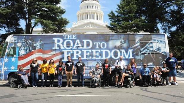 ADA Road to Freedom bus with advocates with disabilities in front of it